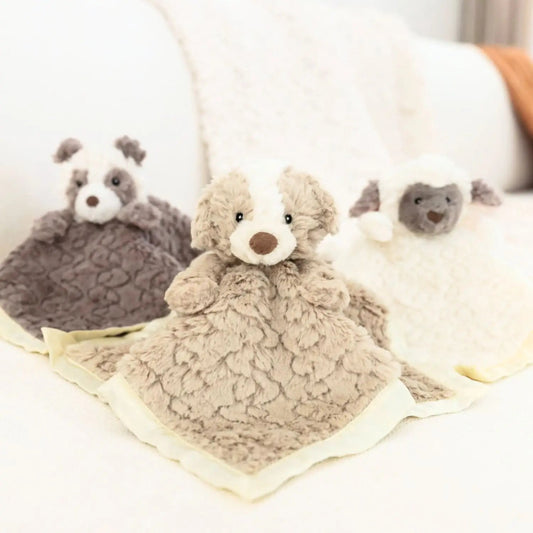 Plush teddy bear and panda on a blanket with a blurred background