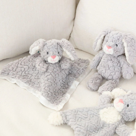 Gray plush bunny toys on a white couch