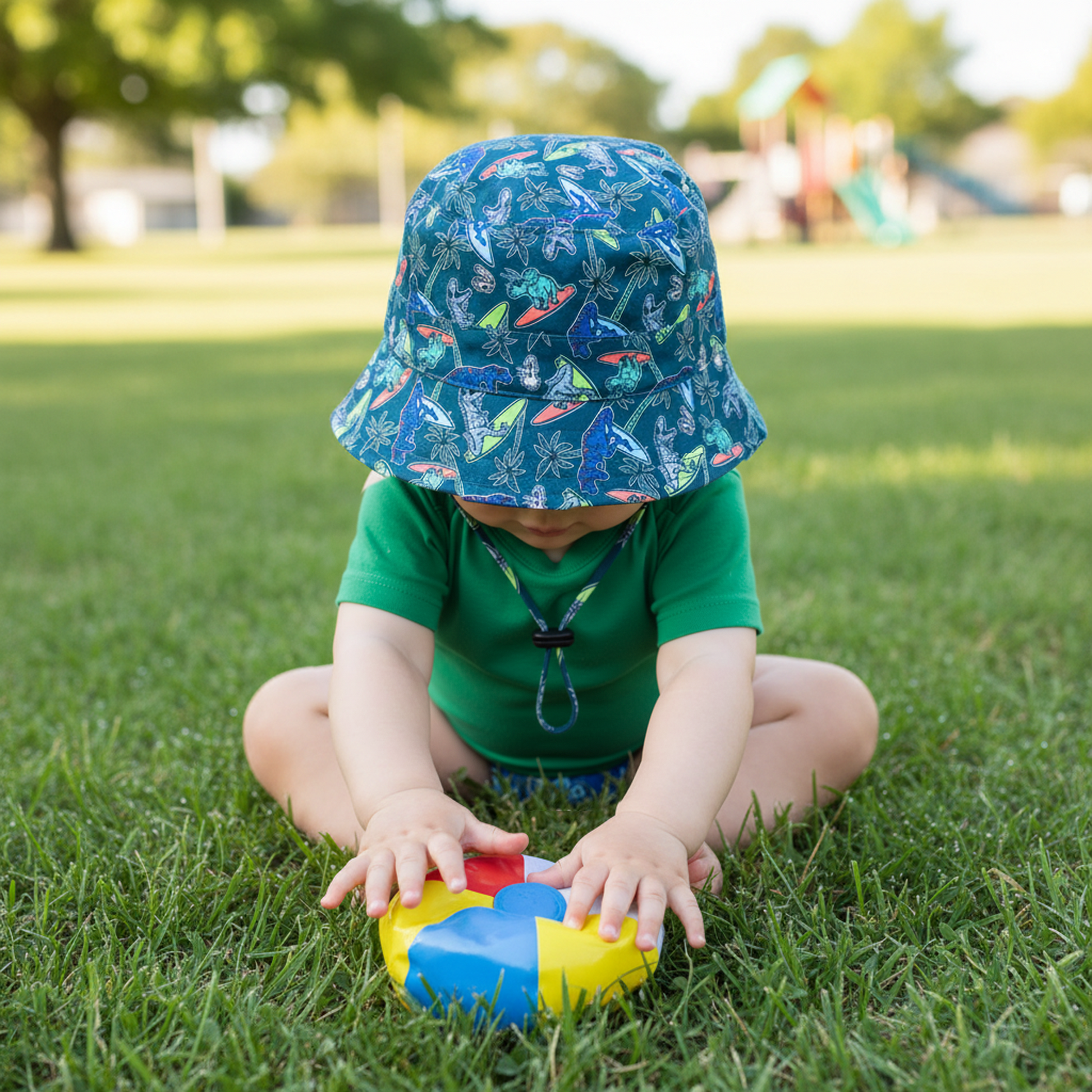 Child playing with colorful toy on grass in a park